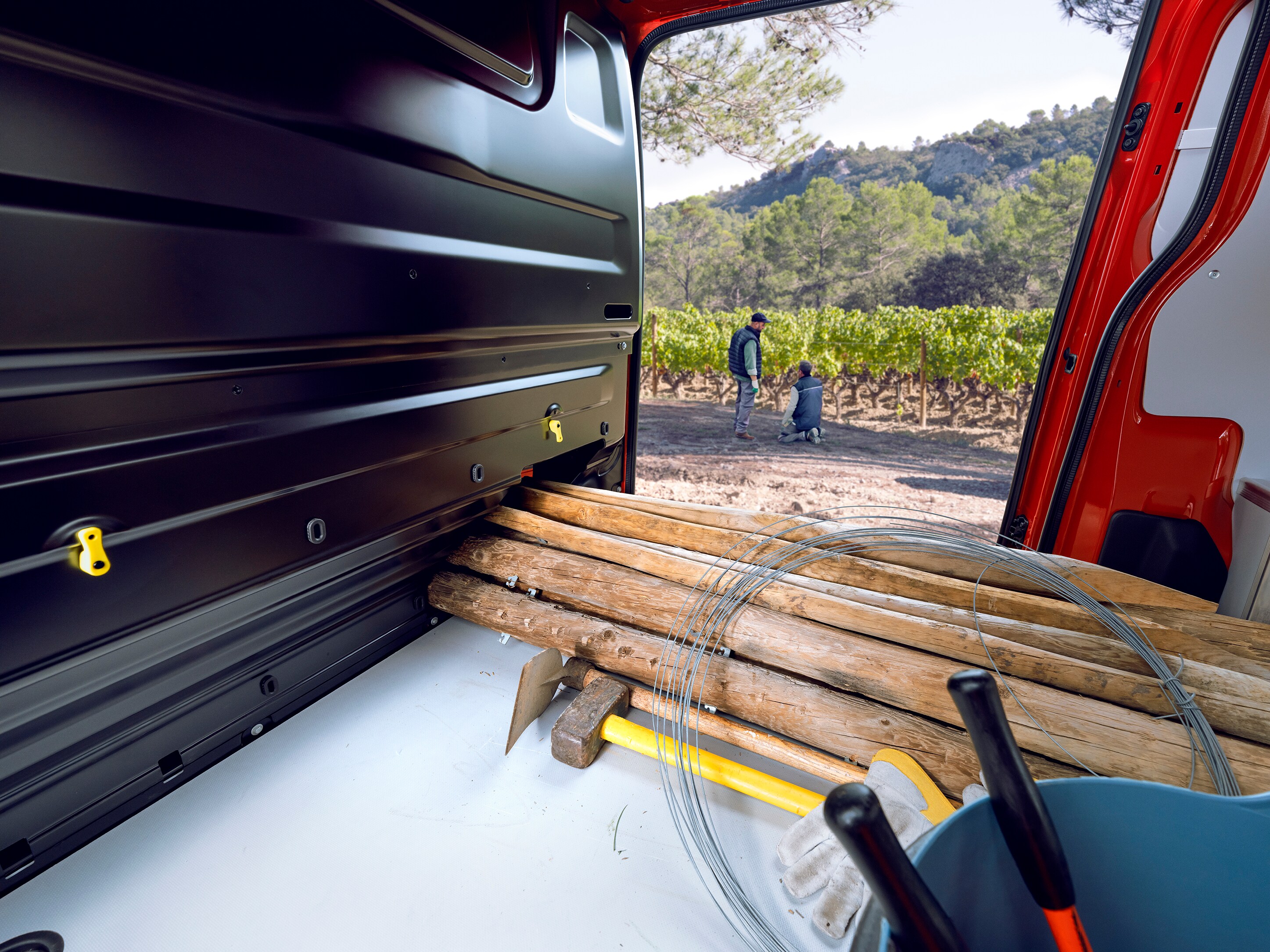 Vista interior de carga desde la parte trasera de un Citroën Jumpy mostrando materiales largos de madera cargados en el interior, destacando espacio de carga versátil y uso profesional práctico.