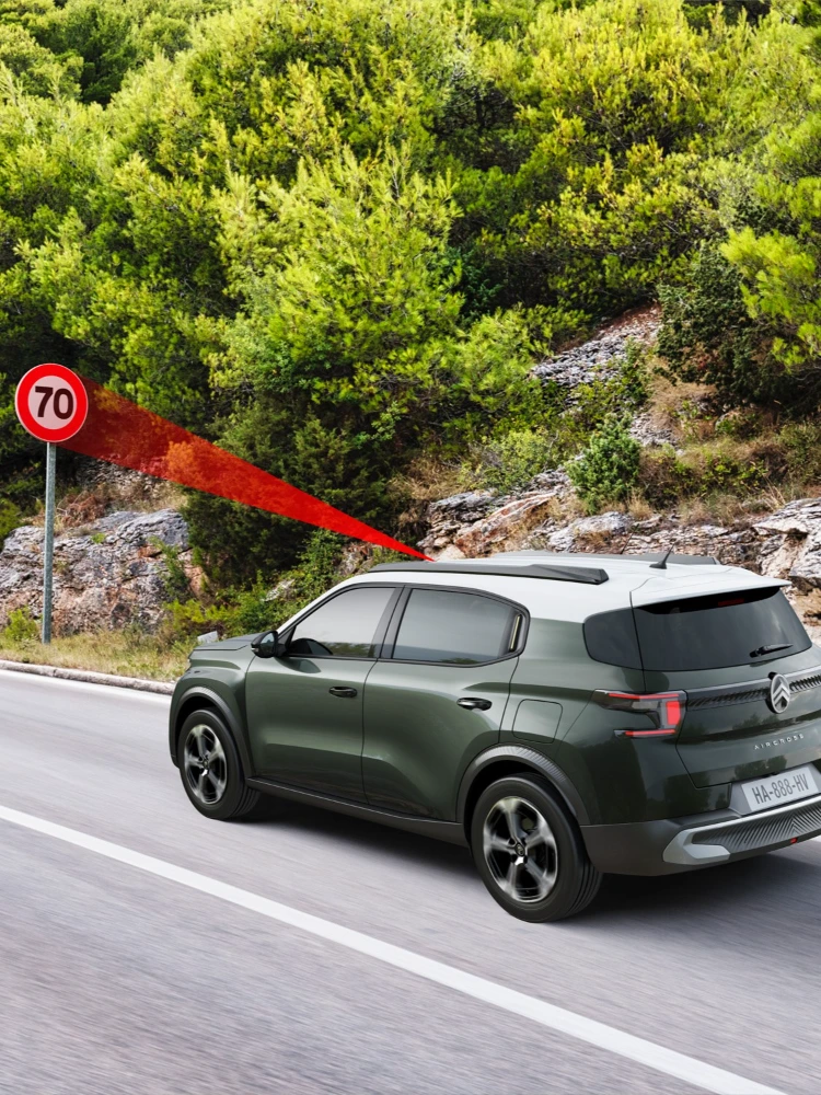 Vista lateral en conducción del Citroën C3 Aircross SUV mostrando reconocimiento de límites de velocidad para una movilidad diaria más segura, informada y asequible.