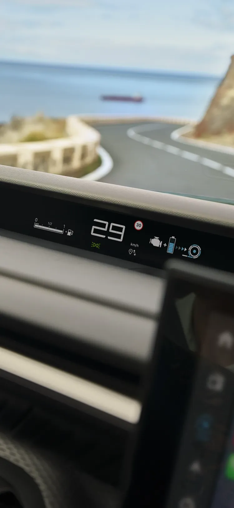 Vista del conductor del Citroën ë-C3 Aircross SUV mostrando gran pantalla de infoentretenimiento para una conducción diaria intuitiva, conectada y asequible en carreteras costeras.
