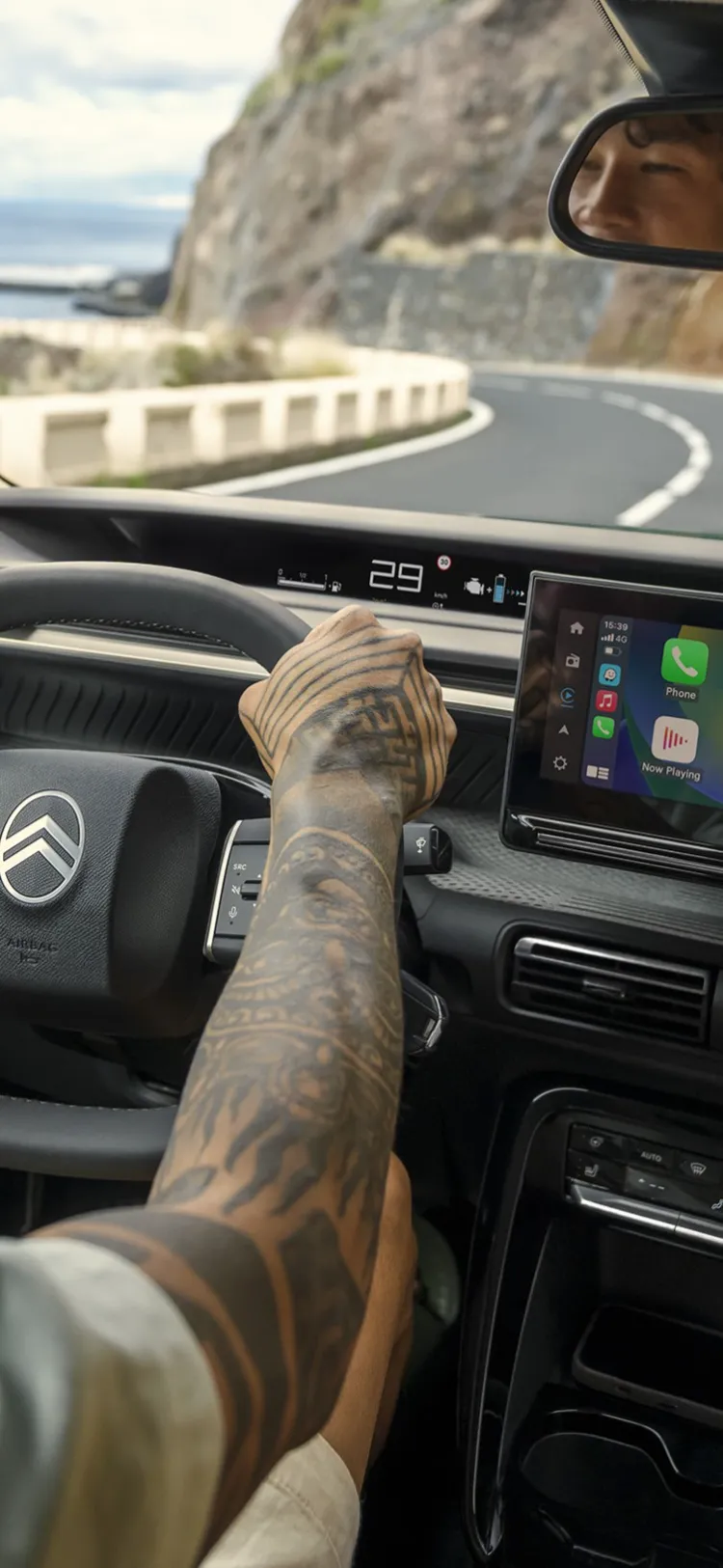 Vista del conductor del Citroën C3 Aircross SUV mostrando gran pantalla de infoentretenimiento para una conducción diaria intuitiva, conectada y asequible en carreteras costeras.