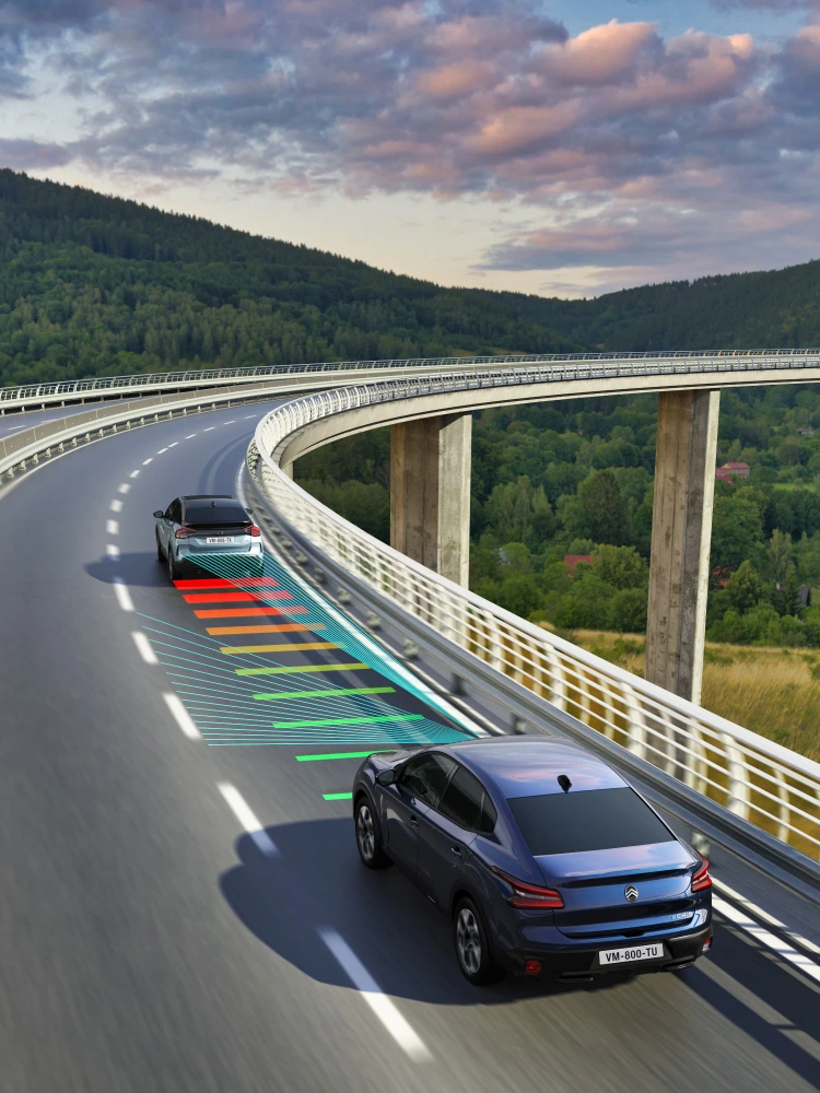 Vista lateral en conducción del Citroën ë‑C4 X mostrando Reconocimiento de Límites de Velocidad para una conducción más segura e informada.