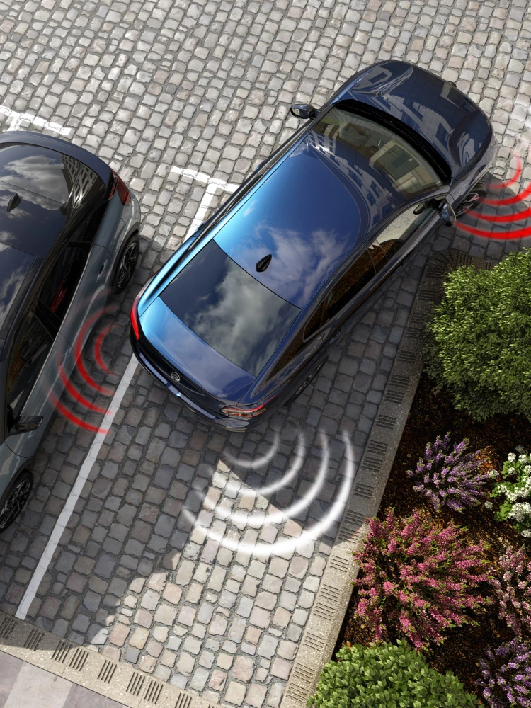 Vista cenital del Citroën ë‑C4 X mostrando sensores de aparcamiento traseros y delanteros activos durante la maniobra.