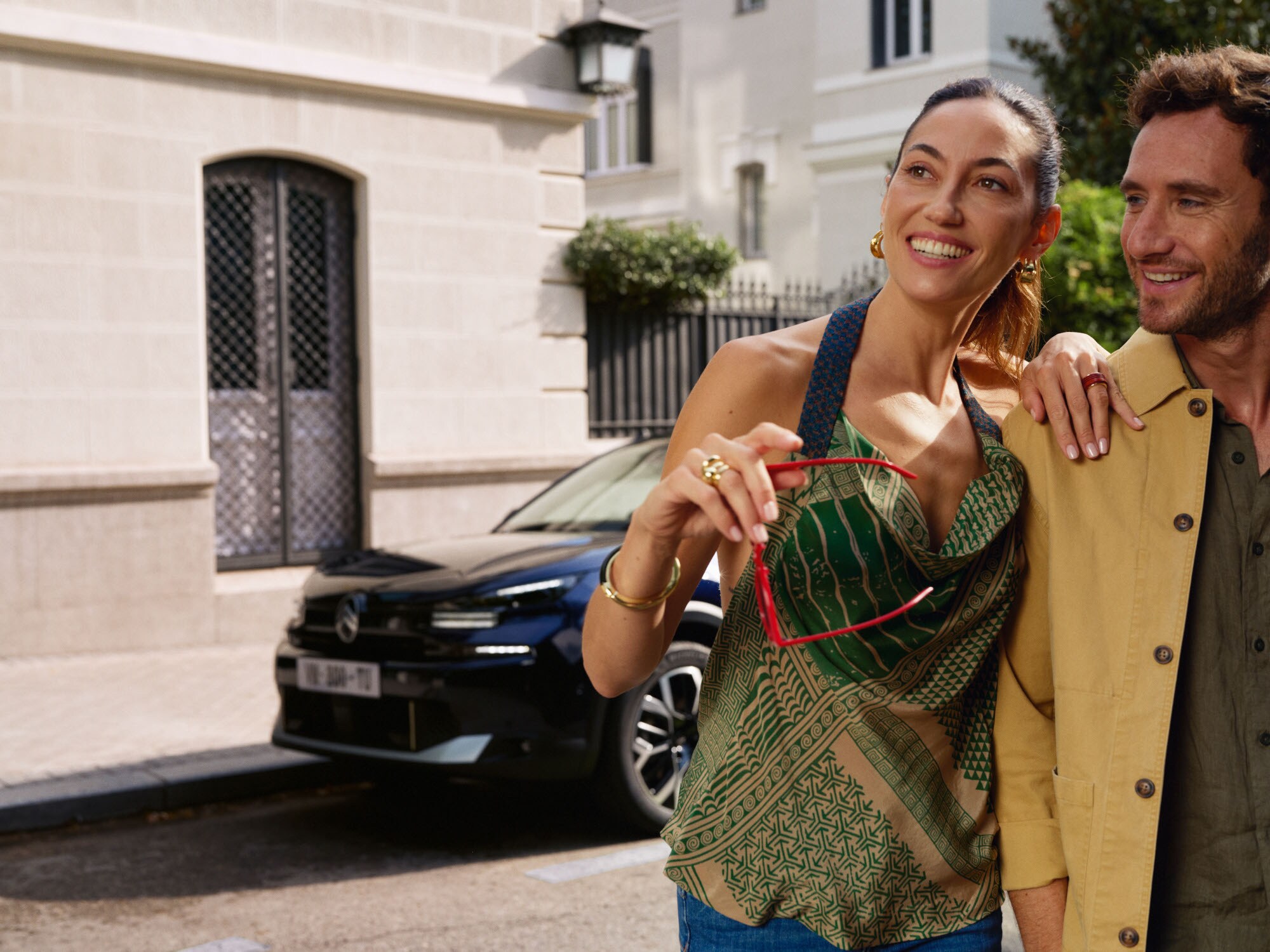 Escena lifestyle con Citroën ë-C4 X aparcado cerca ilustrando su diseño fastback moderno para una movilidad elegante y asequible.