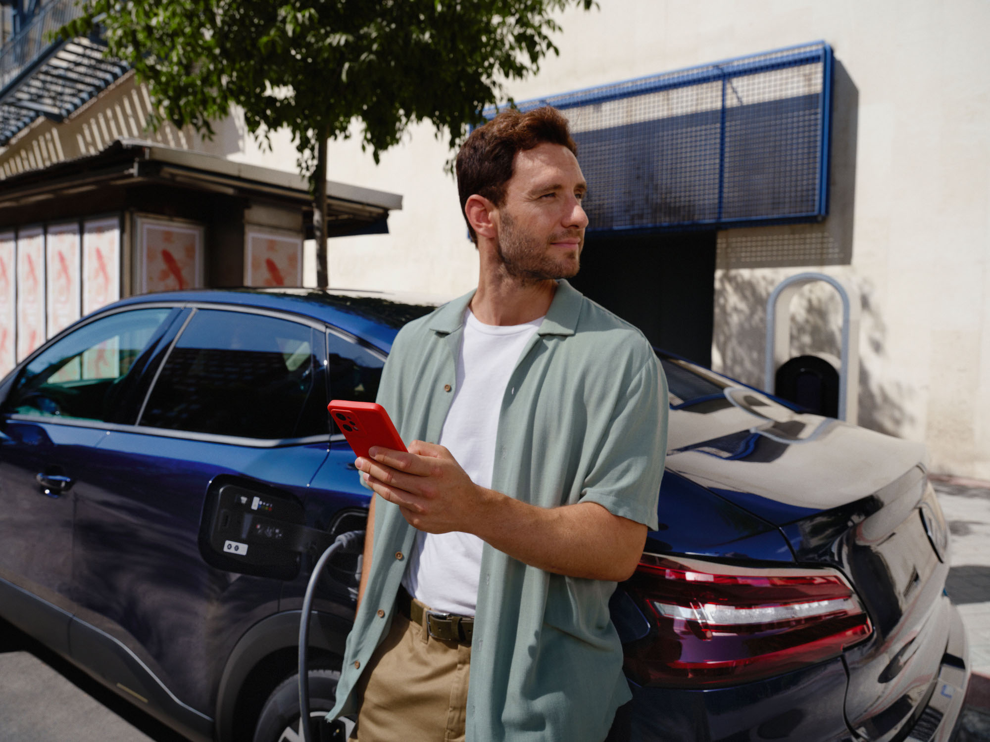 Escena de carga conectada del Citroën ë‑C4 X fastback mostrando uso de app inteligente para una movilidad eléctrica diaria conveniente.